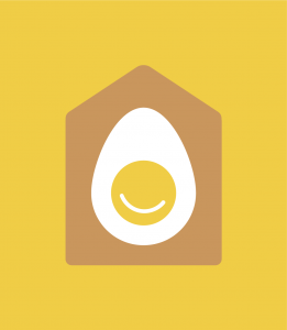 A hard-boiled egg cut in half faces out from inside a house.