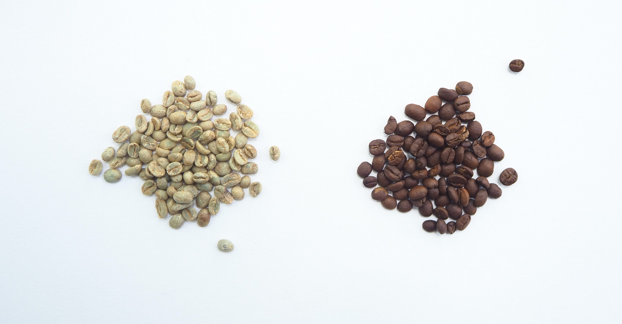 Image of two different piles of coffee beans, one light-coloured and one dark coloured