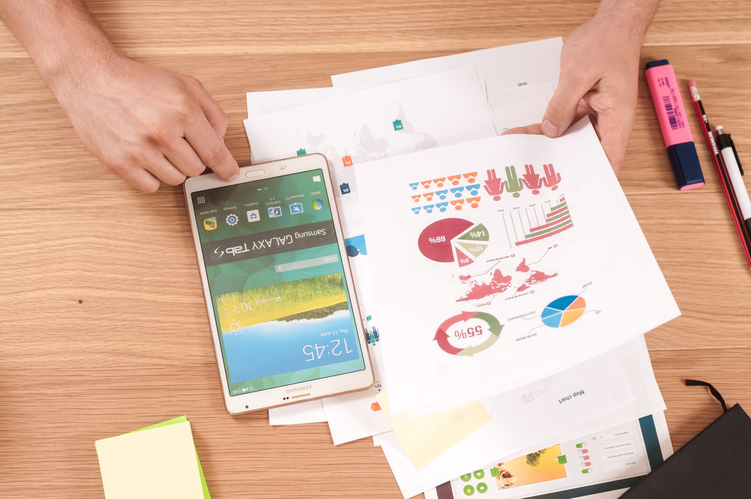 Image of various data types on paper, next to an electronic device, a pen, pencil, and highlighter