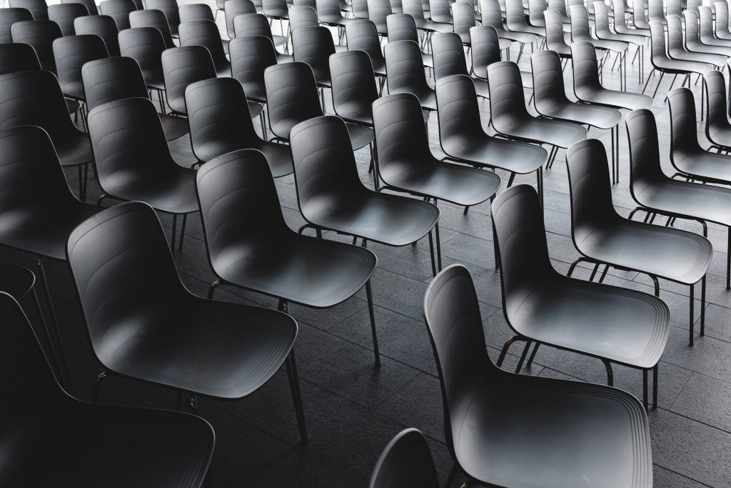 Image of various rows of black plastic chairs