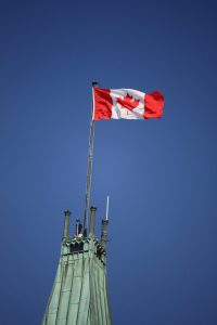 A photograph of the Canadian Flag is floating on top of the Peace Tower on Parliament Hill in Ottawa