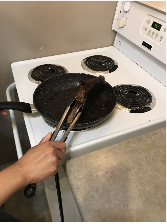 Flipping the steak with tongs