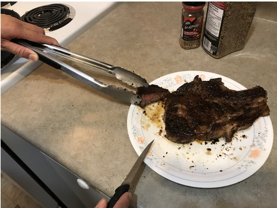 Checking the doneness by cutting into the steak, which is on a plate