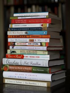 Stack of fiction and non-fiction books ordered from largest to smallest.
