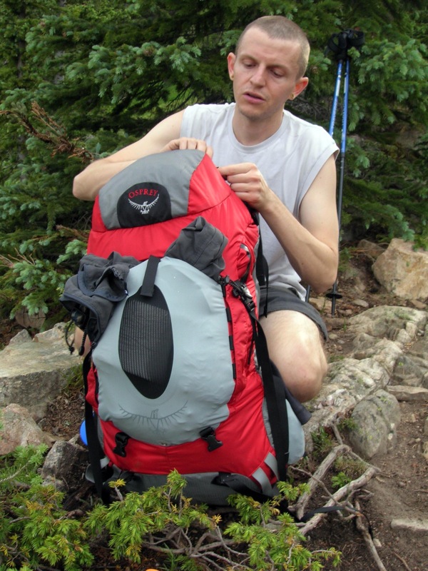 A man with a red and grey Osprey backpack.