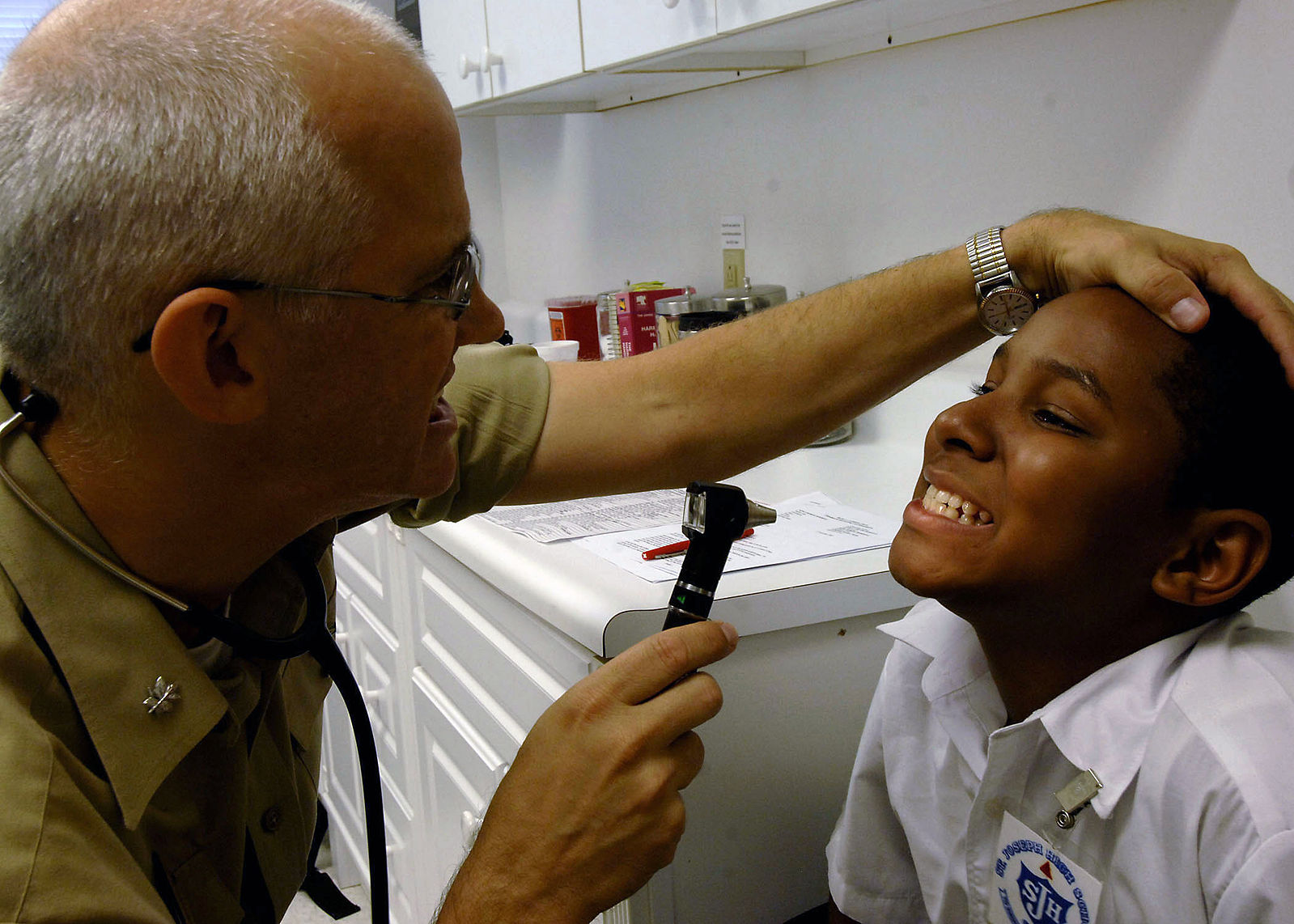 A pediatrician examining a child's teeth.