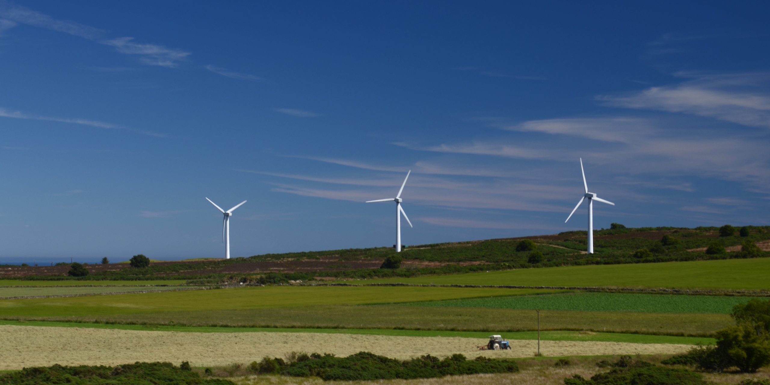 Three wind turbines on a hill.