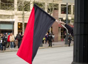 A photograph of a red and black anarchist flag.