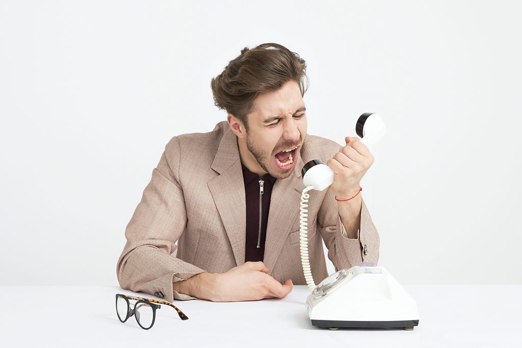 Man yelling angry at the phone.