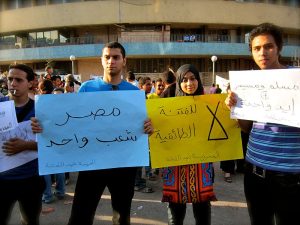 Image of people holding placards and signs in a protest