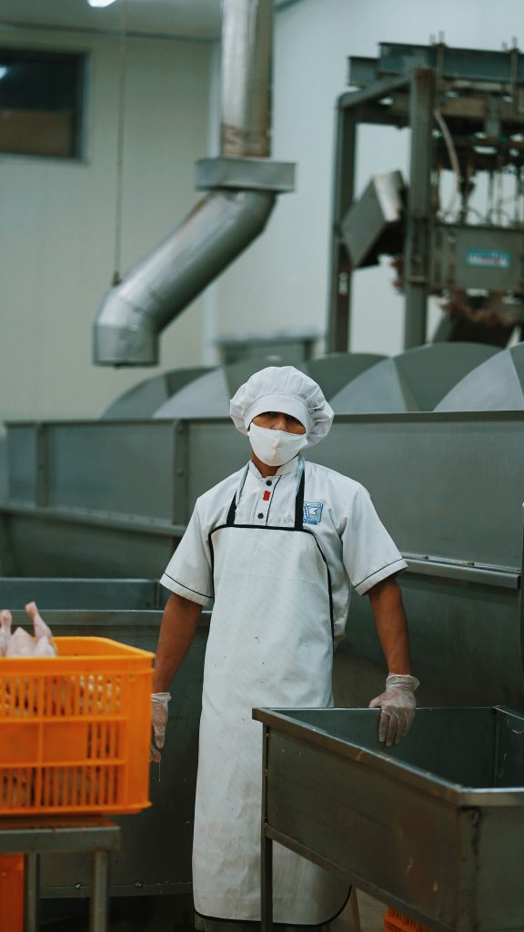 Man in white uniform holding metal grey pipe