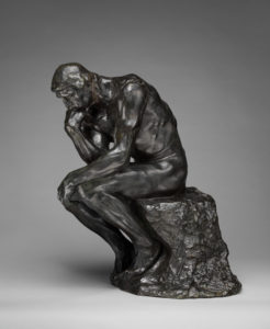 photograph of Auguste Rodin's statute of The Thinker, a sculpture of a seated man in a contemplative pose with his head resting on his hand