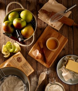 Baking table with ingredients for making an apple pie